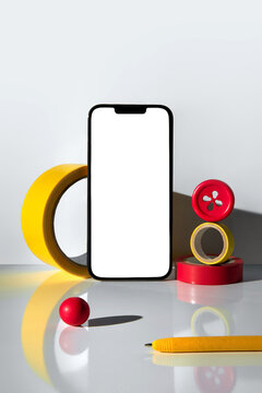 White screen of smartphone and stationary objects on light background
