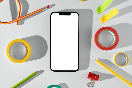 Creative workspace with smartphone and stationery on light background