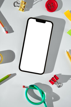 Creative workspace with smartphone and stationery on light background