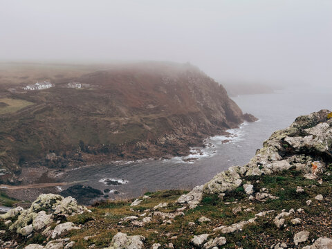 Cliffside View of Remote Coastal Cottages on a Foggy Day
