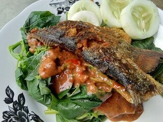 Culinary food pecel with fried fish.