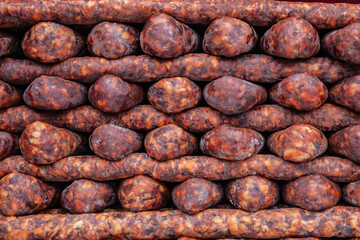 Traditional Serbian sausages (kulen kobasica) stacked at a local market, showcasing Balkan culinary heritage and food culture. Kulen is a traditional pork sausage, dry cured, from Croatia and Serbia.
