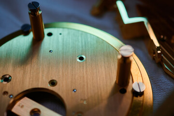 Intricate craftsmanship of watch mechanism bases being assembled in a metalworking workshop