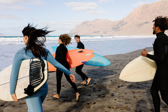 Surfers sprinting toward the ocean, eager to enjoy a surfing session