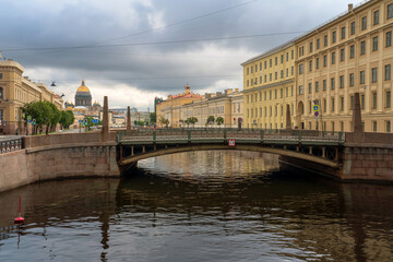 Fototapeta premium View of St. Isaac's Cathedral and the Moika River embankment against the background of the Kissing Bridge on a summer morning, St. Petersburg, Russia