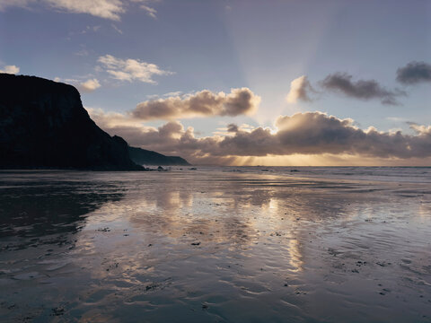 Scenic Ocean Sunset Over Sandy Beach With Vibrant Clouds