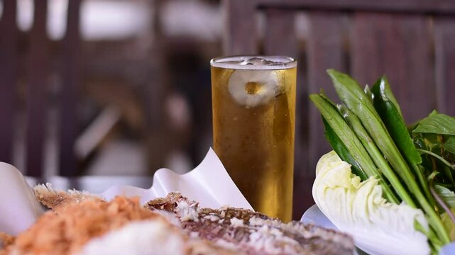 Grilled fish with Thai spicies salad , in Thai cal "Miang Pla Pao" on the table, Miang Pla Pao, Grilled fish with vegetables and cold beer