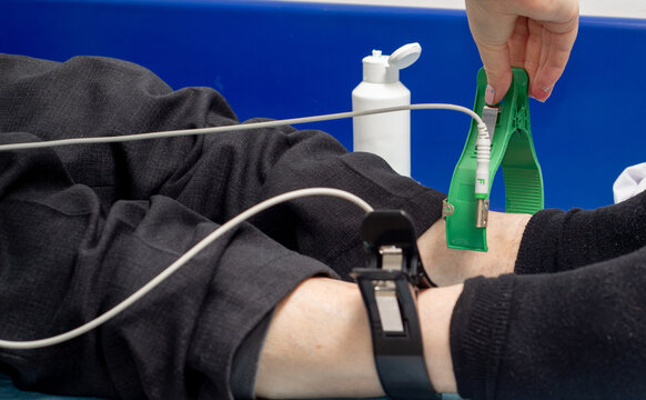 Doctor attaches cardiograph sensors to a patient on the couch