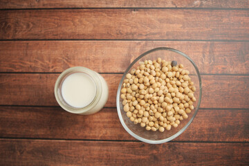 Soybeans and milk on wooden table in kitchen setting