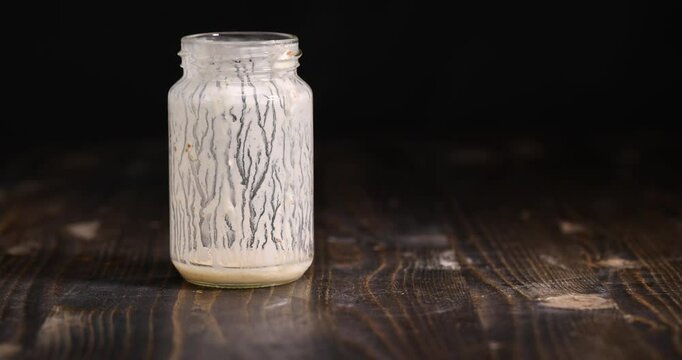 milk yogurt on a blackboard, an empty glass jar with natural yogurt on the table