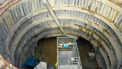 Large underground tunnel construction site with deep excavation pit.
