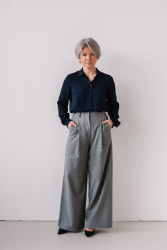 Stylish senior woman poses confidently in chic outfit
