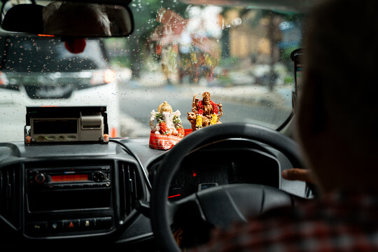 Taxi Driver and amulets of Hindu gods in Rainy day. Travel Malaysia