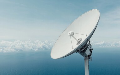 Large white satellite dish against a blue ocean and cloudy sky.  The image is taken from a slightly low angle, emphasizing the size of the dish. The overall mood is serene and technological