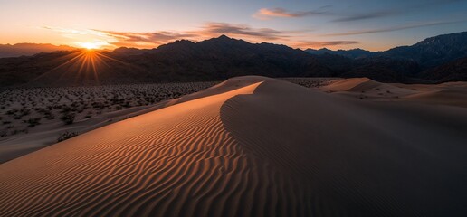 Naklejka premium Sunset over desert dunes, mountains in background