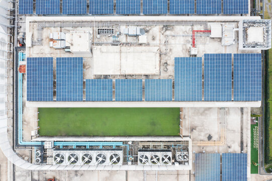 Aerial View of Rooftop Solar Power Installation with Green Patch