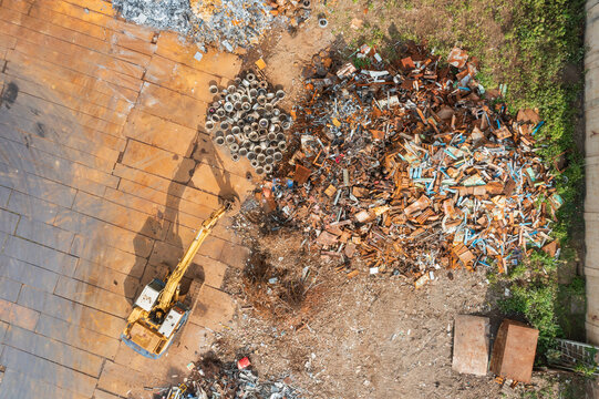 Industrial Excavator Sorting Metal Waste at Recycling Facility