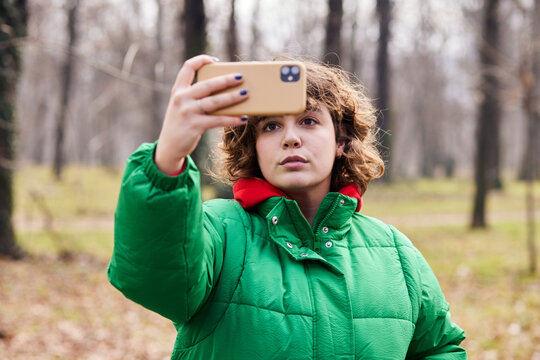 Curly girl taking selfie outdoors