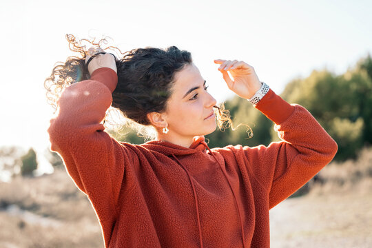Runner woman fixing her hair outdoors for trainning