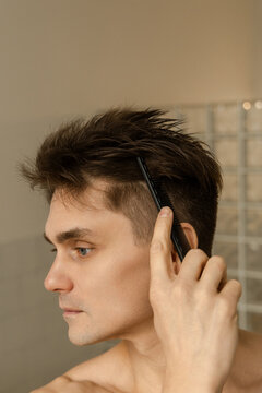 Man combing his hair at home 