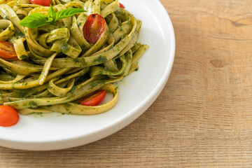 fettuccine spaghetti pasta with pesto sauce and tomatoes