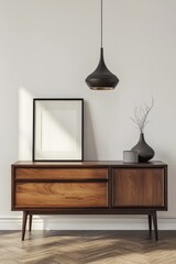 Modern, minimalist living room display with a framed art piece, pendant lamp, and wooden sideboard.  A sunlit, neutral interior design, showcasing a modern style
