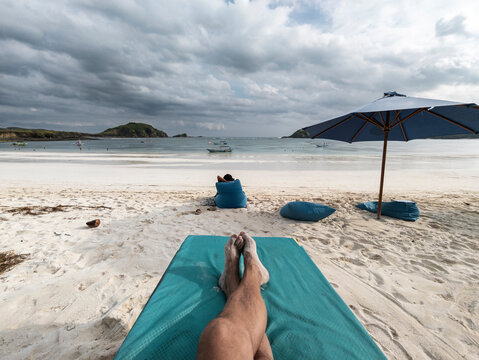 POV of traveler on lounge chair in tropical beach
