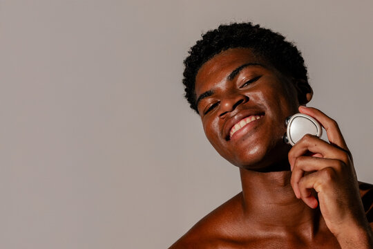 Smiling Man Using Facial Massage Device