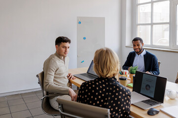 Formal business people collaborating during meeting in modern office