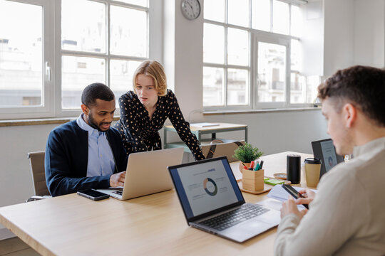 Marketing team analyzing data on laptops in modern office
