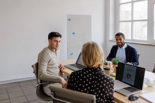 Formal business people collaborating during meeting in modern office