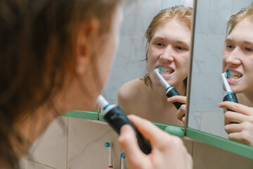 Young Man Brushing Teeth with Electric Toothbrush