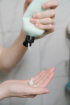 Hand Squeezing Conditioner into Palm