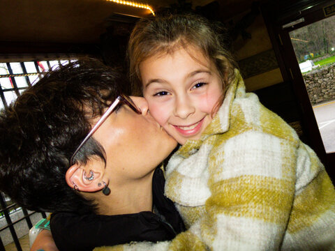 Mother kissing her daughter on the cheek