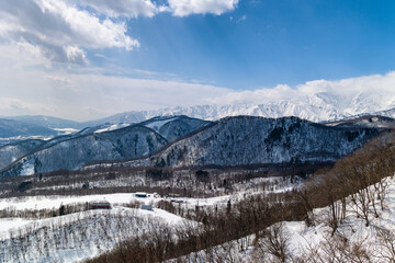 Snow covered mountain and forest alpine scenery on a sunny day. Hakuba, Nagano