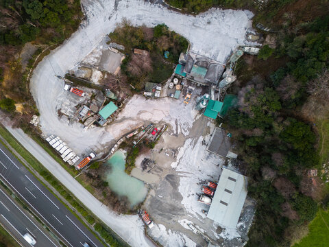 Concrete mixing plant producing cement near highway and forest
