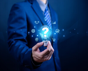 Innovation concept ideas and inspiration. Businessman holding creative light bulb with question mark icon. Industry and marketing development network. Strategic planning. Modern business and inspirati