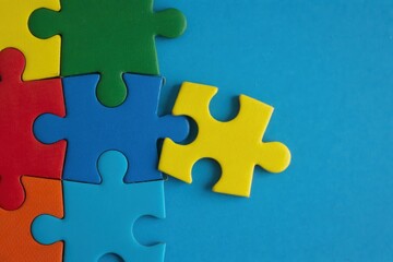 Colorful puzzle pieces against a bright blue background, highlighting a missing yellow piece ready to be placed.