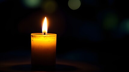 Single candle flame in dark room