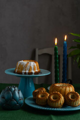 Easter cake on a green stand against the background of burning candles.