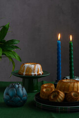 Easter cake on a green stand against the background of burning candles.