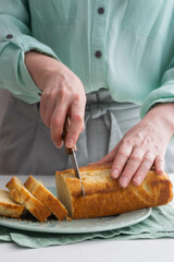 A woman cuts lemon cake for breakfast.