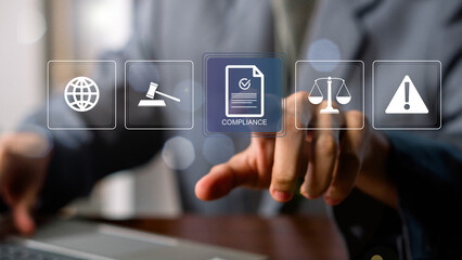 Compliance in business concept. Laws concept. Enforce laws, regulations and standards, comply with business policies, Businessman touching compliance icon on virtual screen.