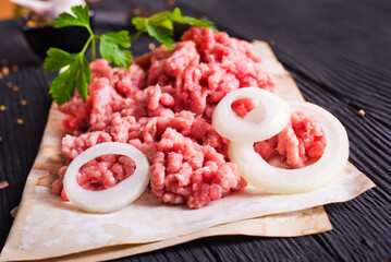 Raw minced pork. Black background. Top view. Space for text