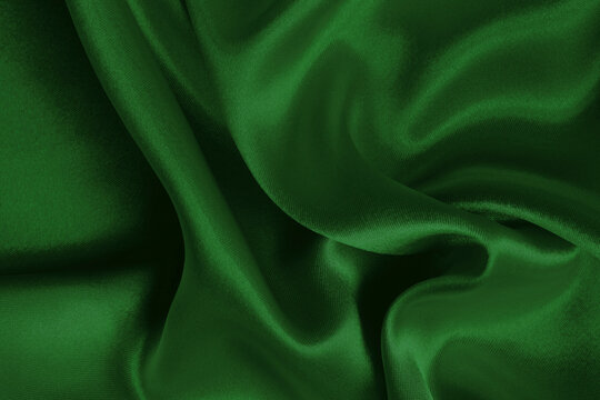 Dark green fabric cloth texture for background and design art work, beautiful crumpled pattern of silk or linen.
