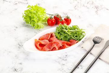 Sliced salmon with fresh arugula