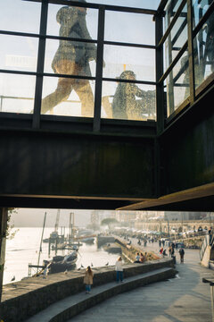 Silhouettes of people walking on glass bridge