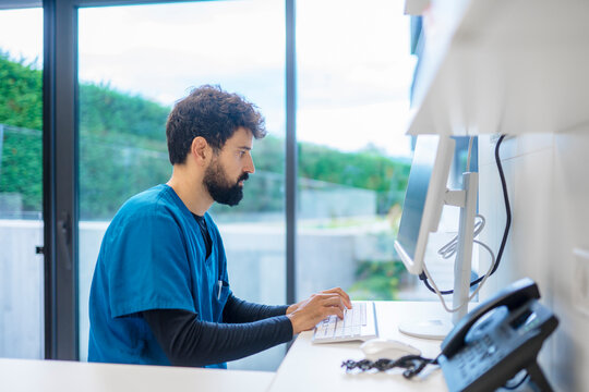 Veterinarian typing on computer keyboard in modern clinic