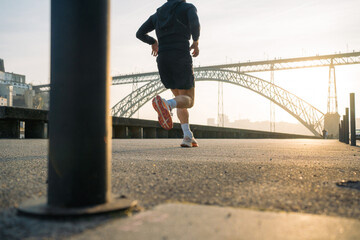 Runner on urban path near bridge at sunrise