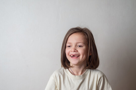 Naklejki Portrait of a Laughing Girl Child Without Front Teeth